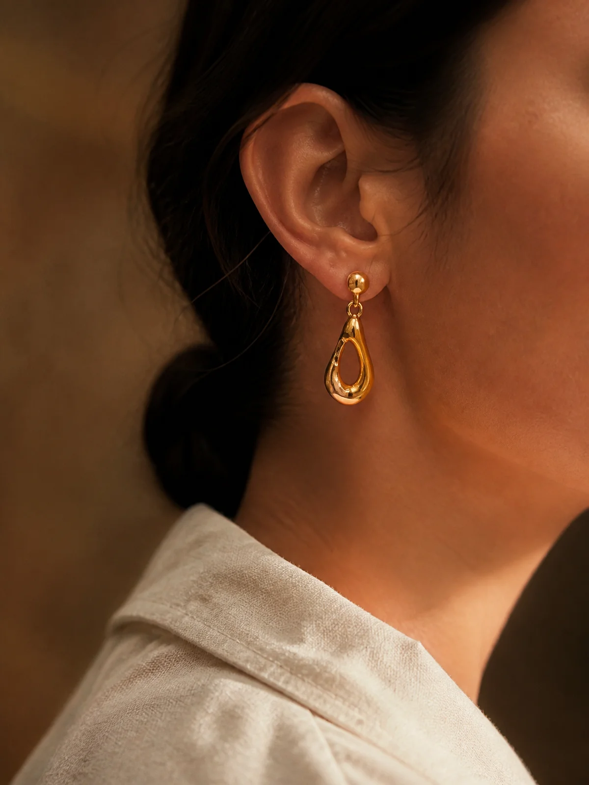 Gold vermeil drop earring worn, seen in profile.